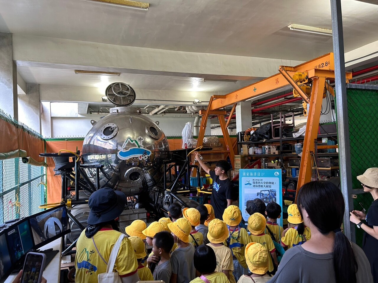 水下載具中心工程師帶領幼兒園孩童參觀水下載具，並解說載具外觀、造型與功能等。