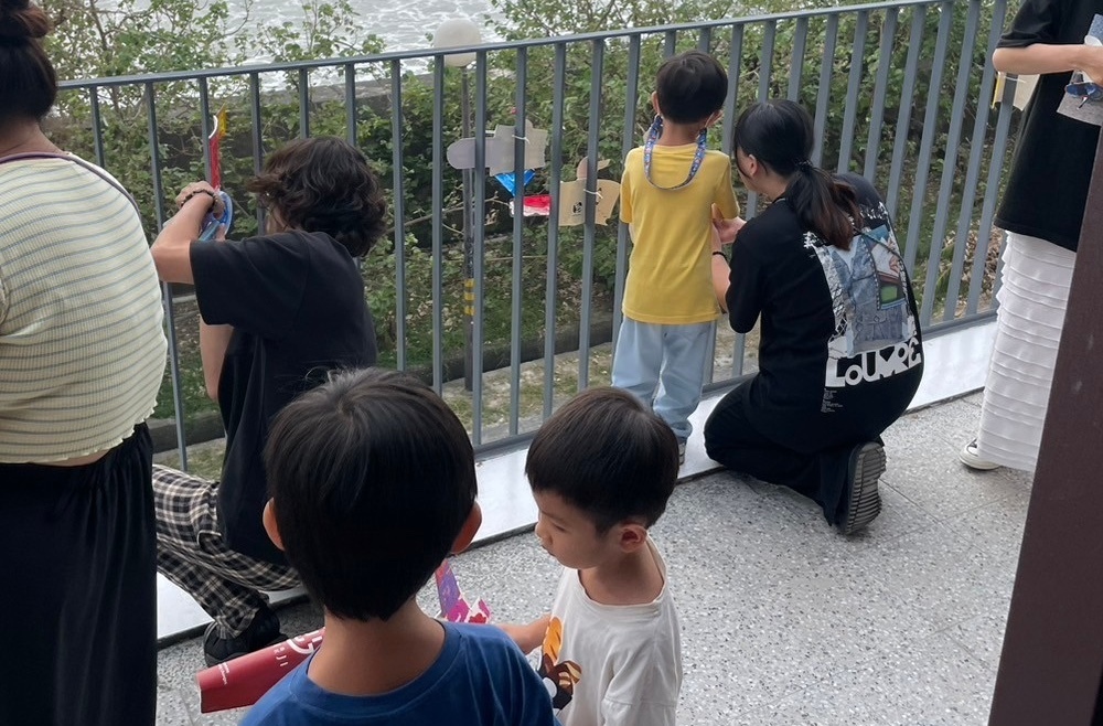 帶領幼兒園孩童至新建的水下載具中心廠房，並協助其進行作品擺放。（圖/中山大學員工子女非營利幼兒園）